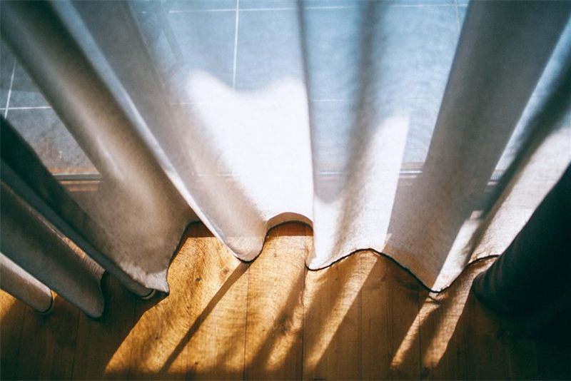 White curtains hanging on a bright window